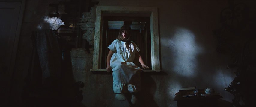 A girls sits terrified in a dumbwaiter