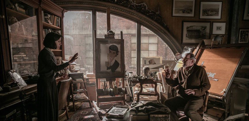 A woman speaks to an old man in a classy yet cluttered study.