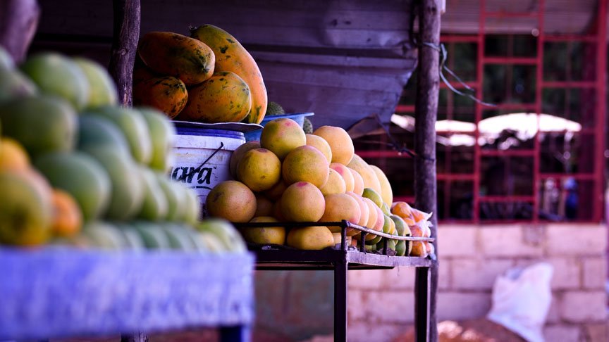 Different types of fruit sit on a stand.