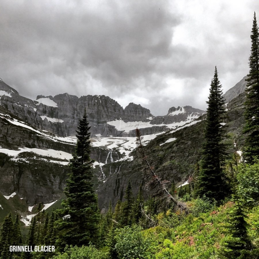 Sharp snow-covered mountains reach into a cloudy sky.