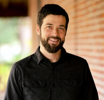 A man with a brown beard smiles for the camera.