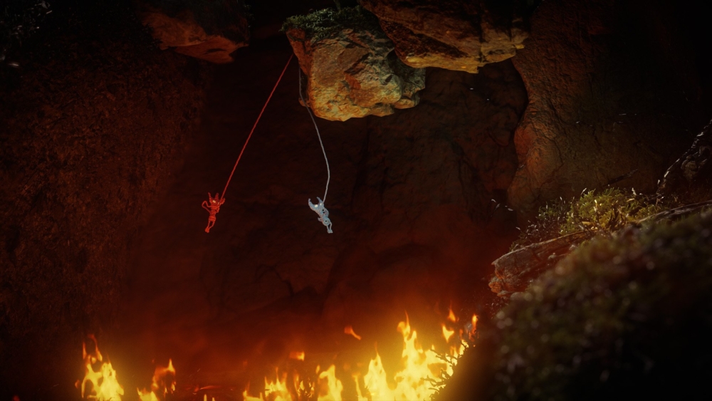 Two of the yarny characters swing across a firey cave floor
