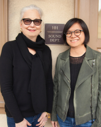 Two women stand and smile