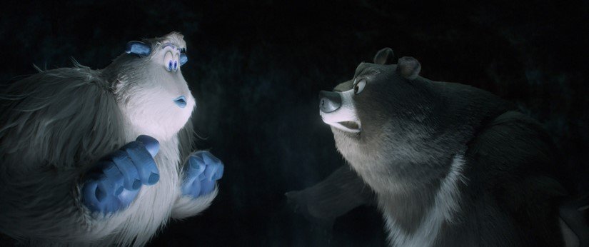 A yeti talks to a bear in a cave