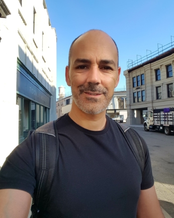A man with a short beard smiles for a selfie.