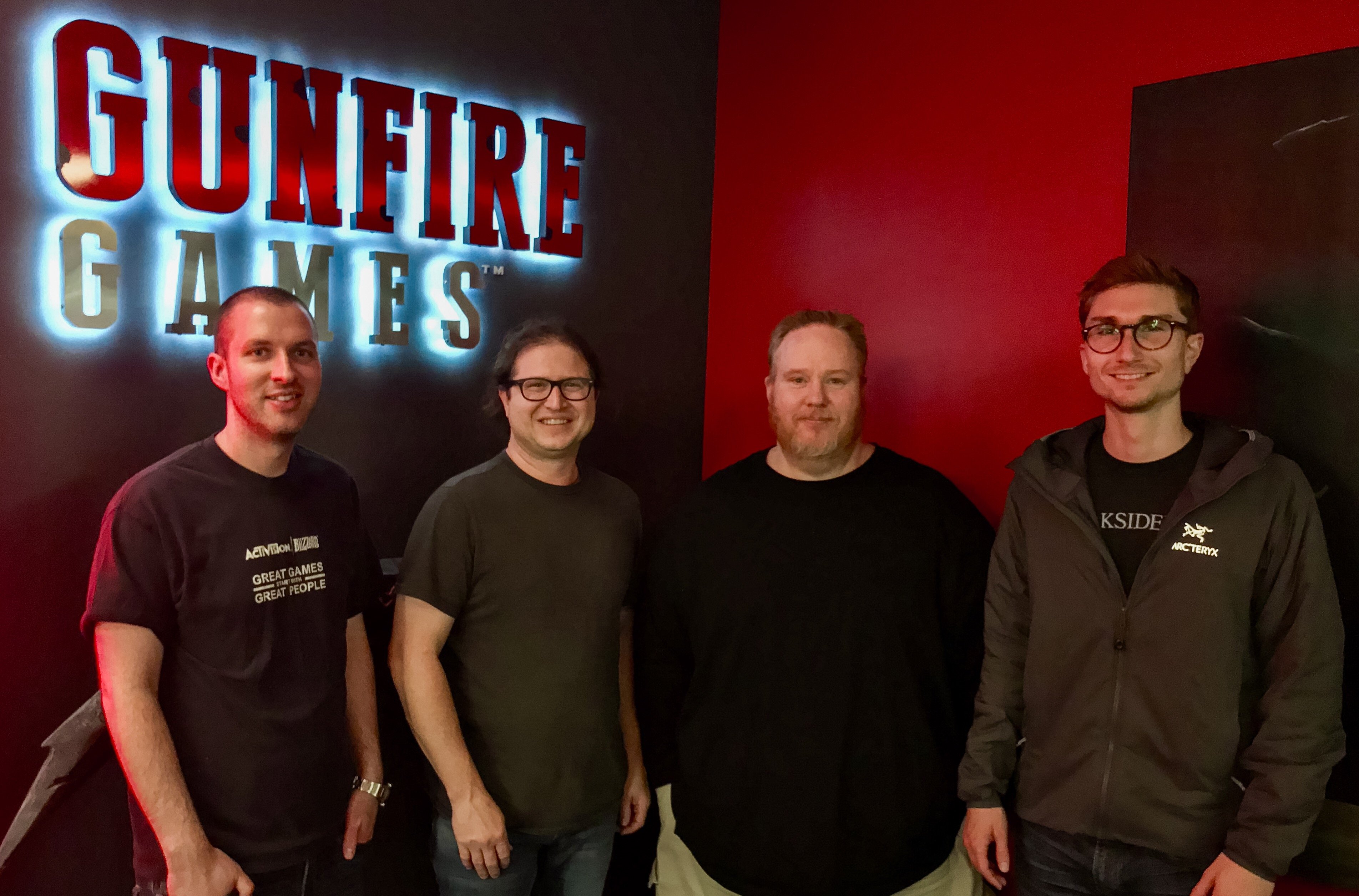 Four men stand in front of the Gunfire Games title.