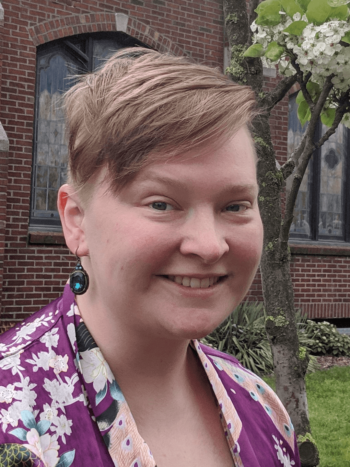A woman with short hair smiles.